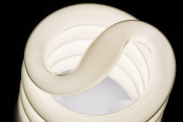 Fluorescent light bulb isolated on black background. Economical home lighting. Energy saving concept.