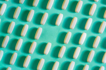 Rows of pills on a blue background. A linear pattern in which the lack of medicine leaves a clean space.