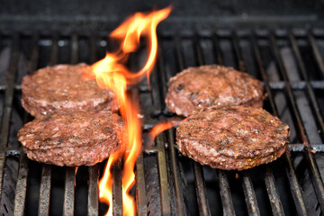 Flame-grilled hamburger patties on the grill.