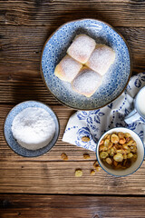 Sweet yeast buns stuffed with curd, raisins and studded with powdered sugar