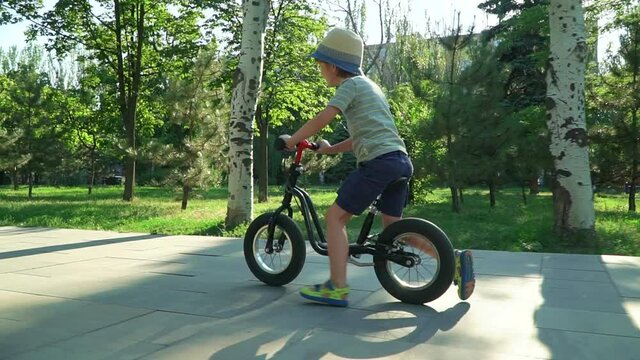 6 years old boy riding a runbike in a park