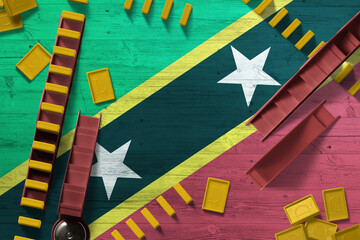 Saint Kitts And Nevis flag with national background with dominoes on wooden table. Top view. Concept of game.