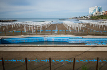 Half filled swimming pool with dirty water at closed empty beach during quarantine in Mar del Plata, Argentina.