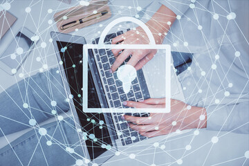 Double exposure of woman hands working on computer and lock hologram drawing. Top View. Security concept.