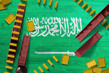 Saudi Arabia flag with national background with dominoes on wooden table. Top view. Concept of game.