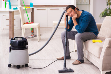 Young man husband doing housework at home