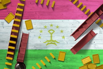 Tajikistan flag with national background with dominoes on wooden table. Top view. Concept of game.