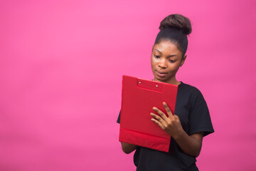 young beautiful black lady smiling while using her notepad to take note of something