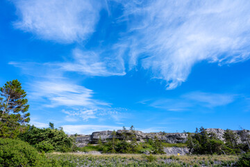 Fototapeta na wymiar Limestone cliff face under blue cloudy sky