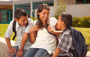Young Hispanic Student Children Wearing Backpacks On School Campus