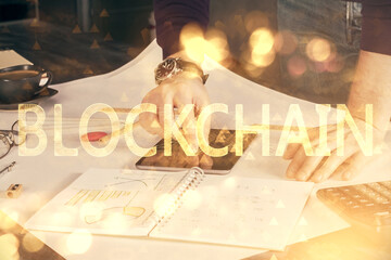 Double exposure of man's hands holding and using a phone and crypto currency blockchain theme...