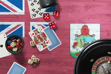 Bermuda casino theme. Aces in poker game, cards and chips on red table with national wooden flag background. Gambling and betting.