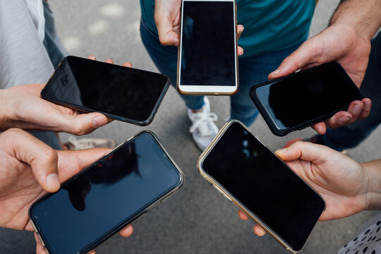group of friends together in a circle using the phone all at onc