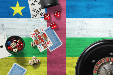 Central African Republic casino theme. Aces in poker game, cards and chips on red table with national wooden flag background. Gambling and betting.