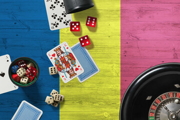 Chad casino theme. Aces in poker game, cards and chips on red table with national wooden flag background. Gambling and betting.