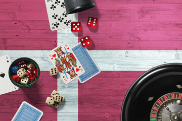 Denmark casino theme. Aces in poker game, cards and chips on red table with national wooden flag background. Gambling and betting.