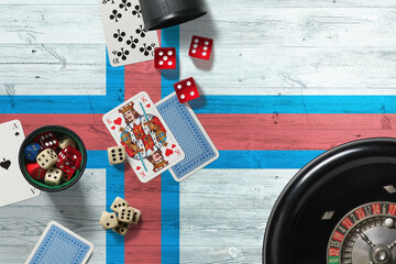 Faroe Islands casino theme. Aces in poker game, cards and chips on red table with national wooden flag background. Gambling and betting.