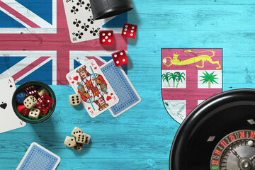 Fiji casino theme. Aces in poker game, cards and chips on red table with national wooden flag background. Gambling and betting.