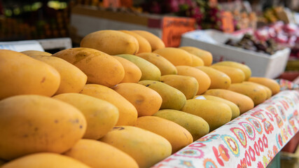 selling fresh mangoes in a market in Asia. Mango is the most popular fruit in Asia.