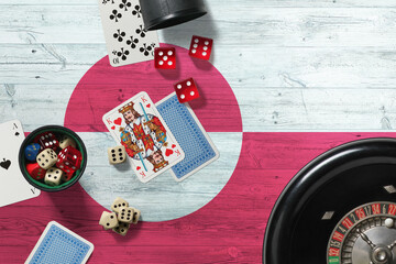 Greenland casino theme. Aces in poker game, cards and chips on red table with national wooden flag background. Gambling and betting.