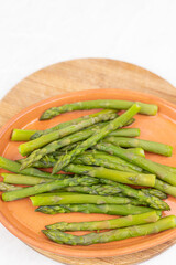 Cooked asparagus on the wooden board