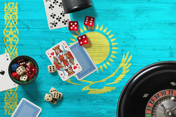 Kazakhstan casino theme. Aces in poker game, cards and chips on red table with national wooden flag background. Gambling and betting.