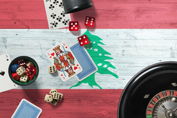 Lebanon casino theme. Aces in poker game, cards and chips on red table with national wooden flag background. Gambling and betting.