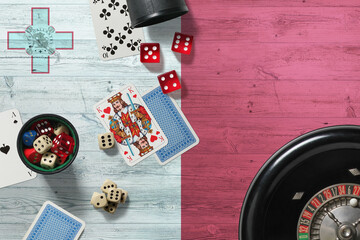 Malta casino theme. Aces in poker game, cards and chips on red table with national wooden flag background. Gambling and betting.
