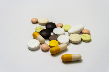 Bunch colorful pills and capsules on a white background close up, macroshot tablets, isolated. Pandemic medications. Drugs disease treatment - covid-19, coronavirus. Vitamins for human health