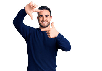 Naklejka premium Young handsome man wearing casual clothes smiling making frame with hands and fingers with happy face. creativity and photography concept.