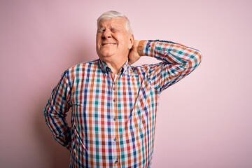 Senior handsome hoary man wearing casual colorful shirt over isolated pink background Suffering of neck ache injury, touching neck with hand, muscular pain