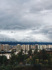 Fototapeta na wymiar Beautiful and dramatic cloudy sky over Santiago downtown and snowed Los Andes mountains, Chile