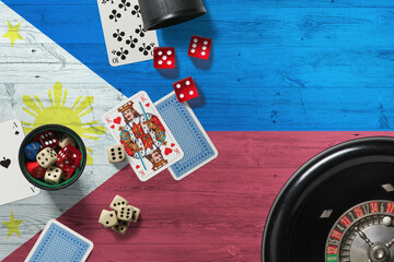 Philippines casino theme. Aces in poker game, cards and chips on red table with national wooden flag background. Gambling and betting.