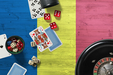 Romania casino theme. Aces in poker game, cards and chips on red table with national wooden flag background. Gambling and betting.