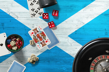 Scotland casino theme. Aces in poker game, cards and chips on red table with national wooden flag background. Gambling and betting.