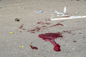 blood asphalt after an accident, a pool of blood and packaging from syringes and drugs, first aid...