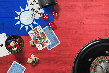 Taiwan casino theme. Aces in poker game, cards and chips on red table with national wooden flag background. Gambling and betting.