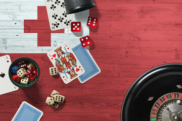 Tonga casino theme. Aces in poker game, cards and chips on red table with national wooden flag background. Gambling and betting.