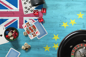Tuvalu casino theme. Aces in poker game, cards and chips on red table with national wooden flag background. Gambling and betting.