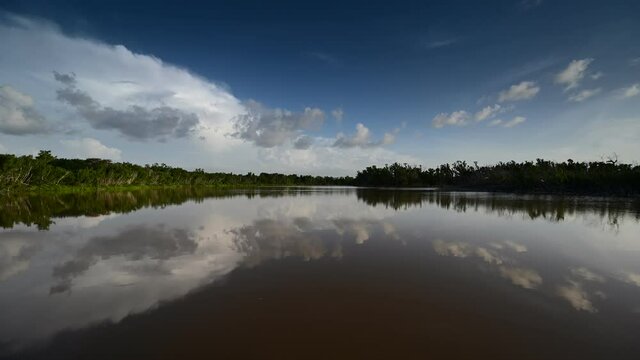 Timelapse of clouds reflected on Eco Pond in Everglades National Park, Florida on sunny summer morning.