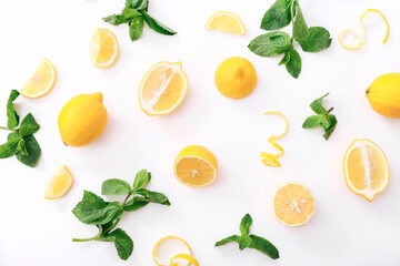 Fresh cut lemon and mint leaves on white background. Top view - obrazy, fototapety, plakaty