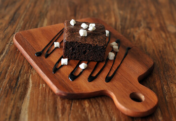 Homemade Chocolate brownie topping with marshmallow on wooden background