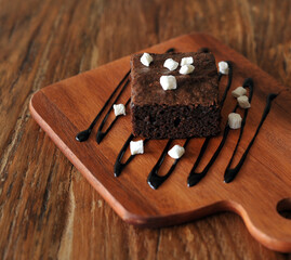 Homemade Chocolate brownie topping with marshmallow on wooden background