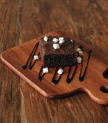 Homemade Chocolate brownie topping with marshmallow on wooden background