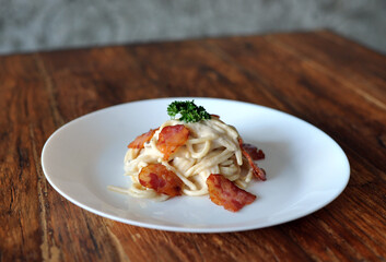 Delicious spaghetti carbonara with bacon on wooden table