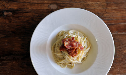 Delicious spaghetti carbonara with bacon on wooden table