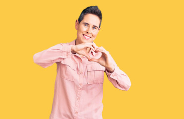 Young woman with short hair wearing casual clothes smiling in love doing heart symbol shape with hands. romantic concept.