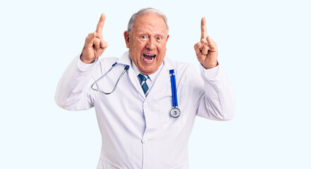 Senior handsome grey-haired man wearing doctor coat and stethoscope shouting with crazy expression doing rock symbol with hands up. music star. heavy music concept.