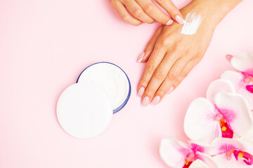 Fototapeta premium Woman close up applies moisturizer for hand skin care