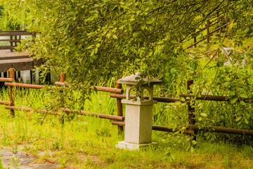 Concrete lantern in front of fence